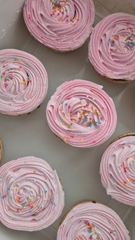 Top view of pink frosted cupcakes with colorful sprinkles, ideal for sweet treats imagery.