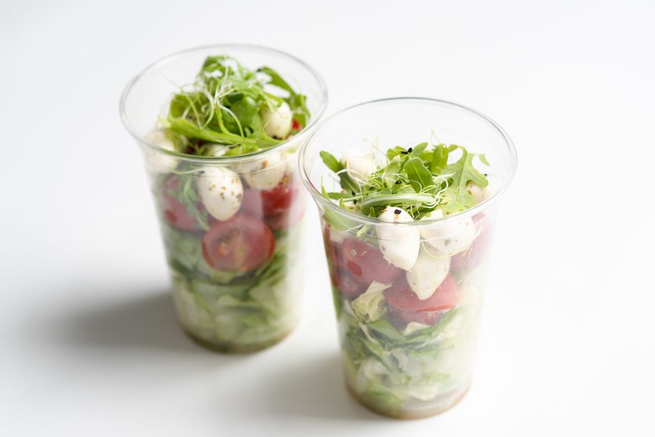 A close-up of a casual, freshly prepared lunch bowl with colorful ingredients on a restaurant table