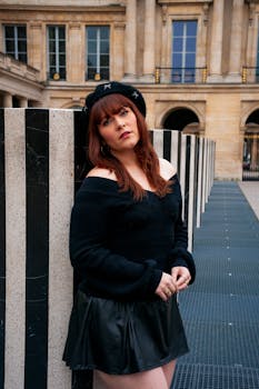 Fashionable woman in Parisian outfit posing at Palais Royal, Paris.