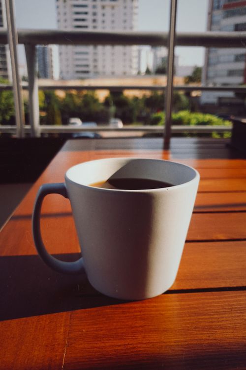 Free A serene morning coffee experience on a spacious balcony with city views. Stock Photo