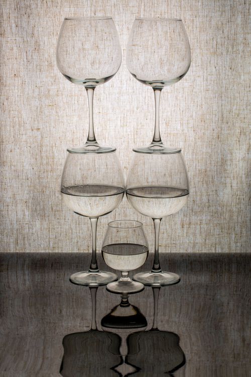 Free Elegant still life with symmetrically stacked wine glasses reflecting on a surface. Stock Photo