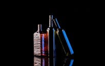 Artistic Photo of Backlit Glass Bottles on Reflective Surface