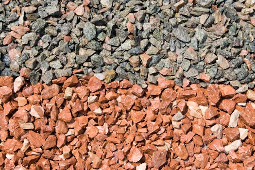 Detailed view of gray and red gravel stones in bright sunlight, perfect for backgrounds.