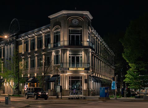 A beautifully illuminated historic building at night, featuring a prominent clock tower.