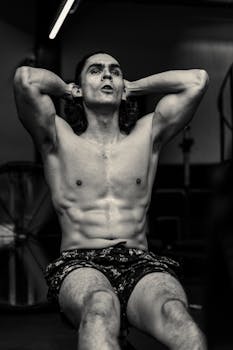 Black and white photo of a man doing abdominal exercises at the gym.
