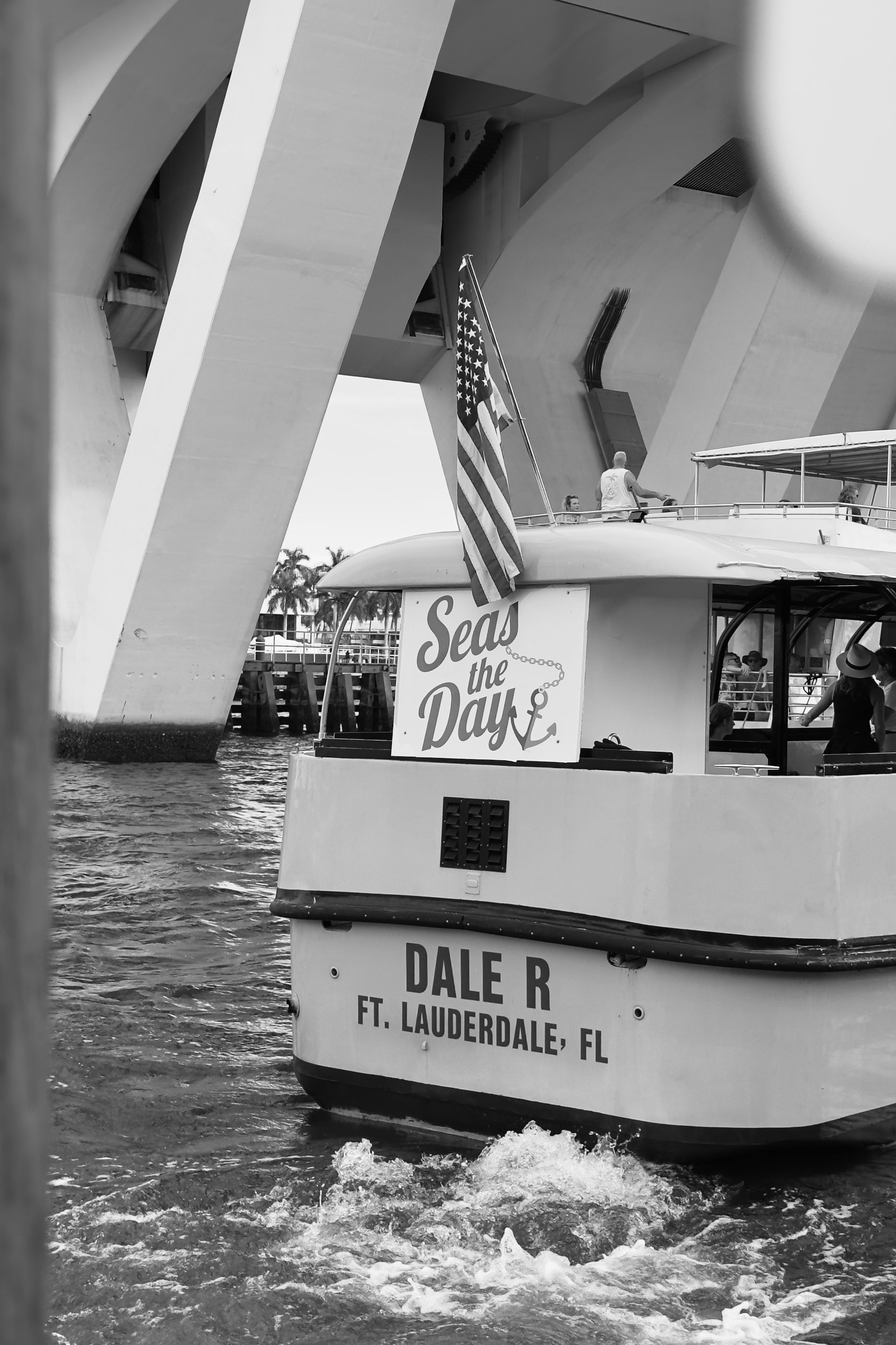 A boat with an American flag passes under a bridge in Fort Lauderdale, Florida.