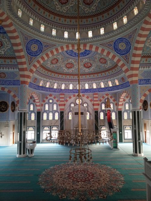 Free Stunning interior view of a mosque featuring detailed domed ceiling and vibrant arches. Beautiful lighting and ornate decor. Stock Photo