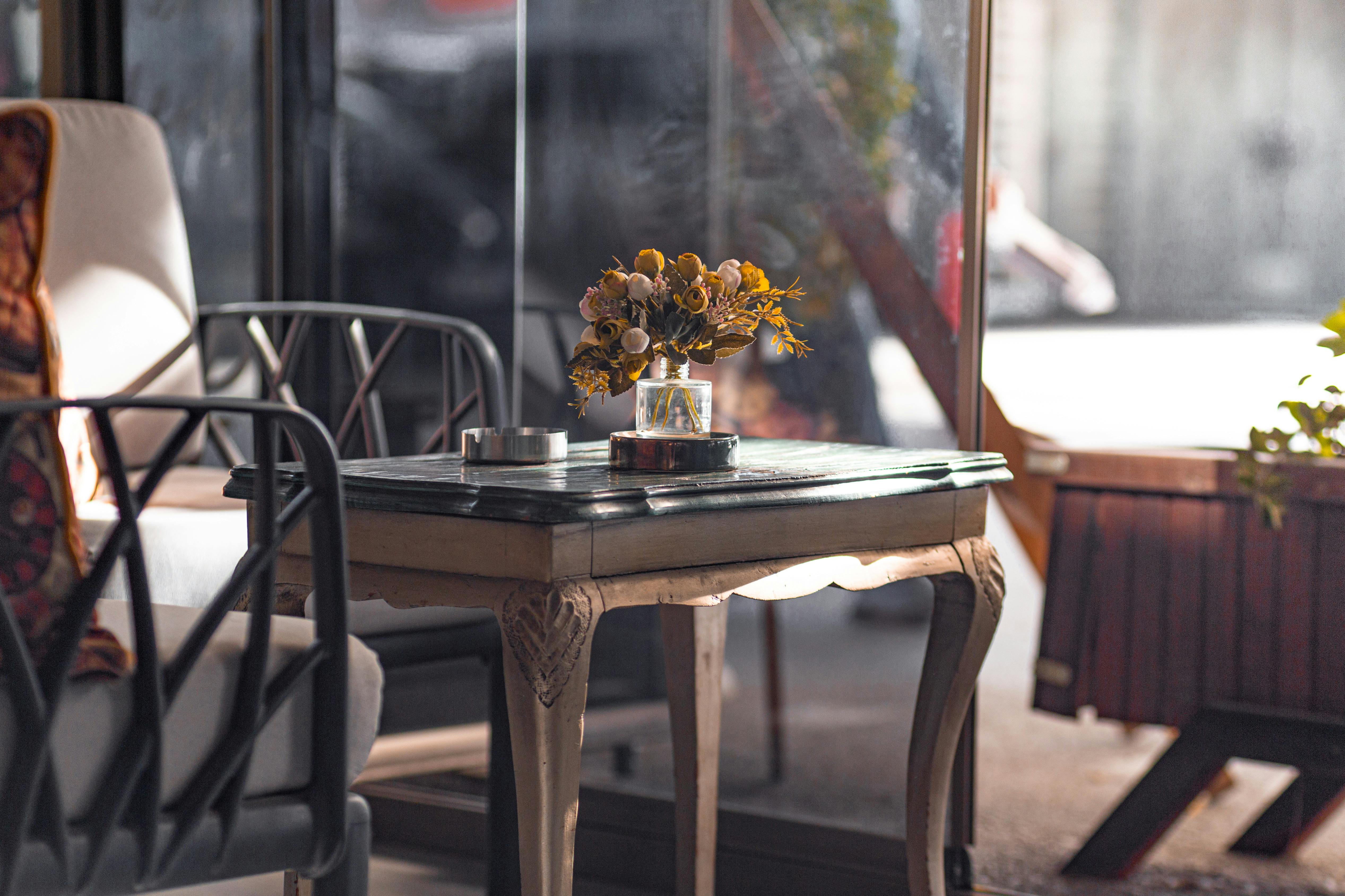 Charming indoor setting with a vintage table and floral arrangement, creating a warm and inviting atmosphere.