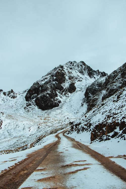 Free Scenic snowy mountain path leading through stunning peaks in Cuzco, Peru. Stock Photo
