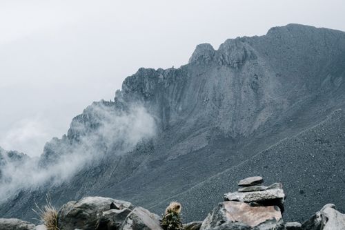 Free Ethereal mountain landscape with mist drifting over rugged peaks. Stock Photo