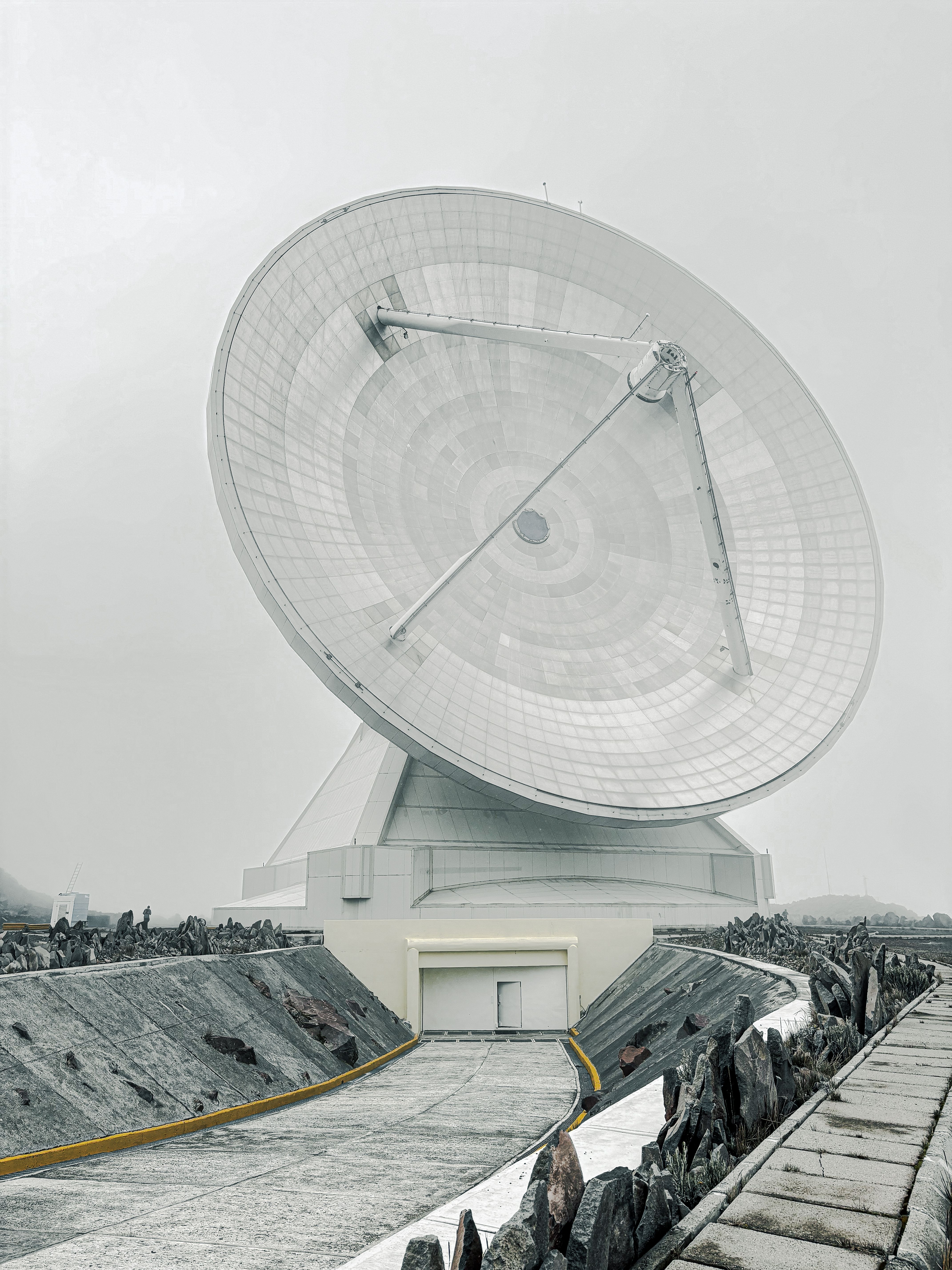 Massive radio telescope dish in a remote mountainous location.