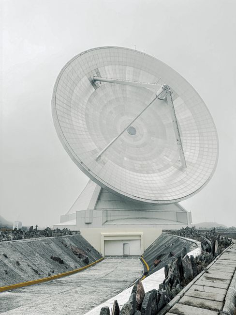 Massive radio telescope dish in a remote mountainous location.