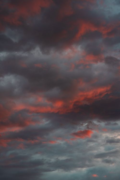 Free A captivating view of a dramatic sky with red and gray clouds during sunset, creating a moody atmosphere. Stock Photo
