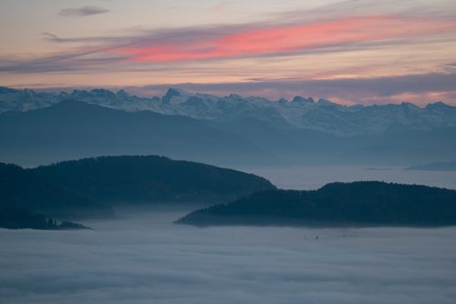 Free Stunning twilight view of mountains with mist and vibrant sky, perfect for nature and travel themes. Stock Photo