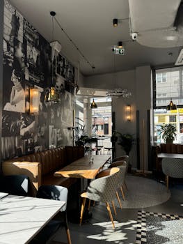 Bright modern cafe interior with vintage wall art and cozy seating.