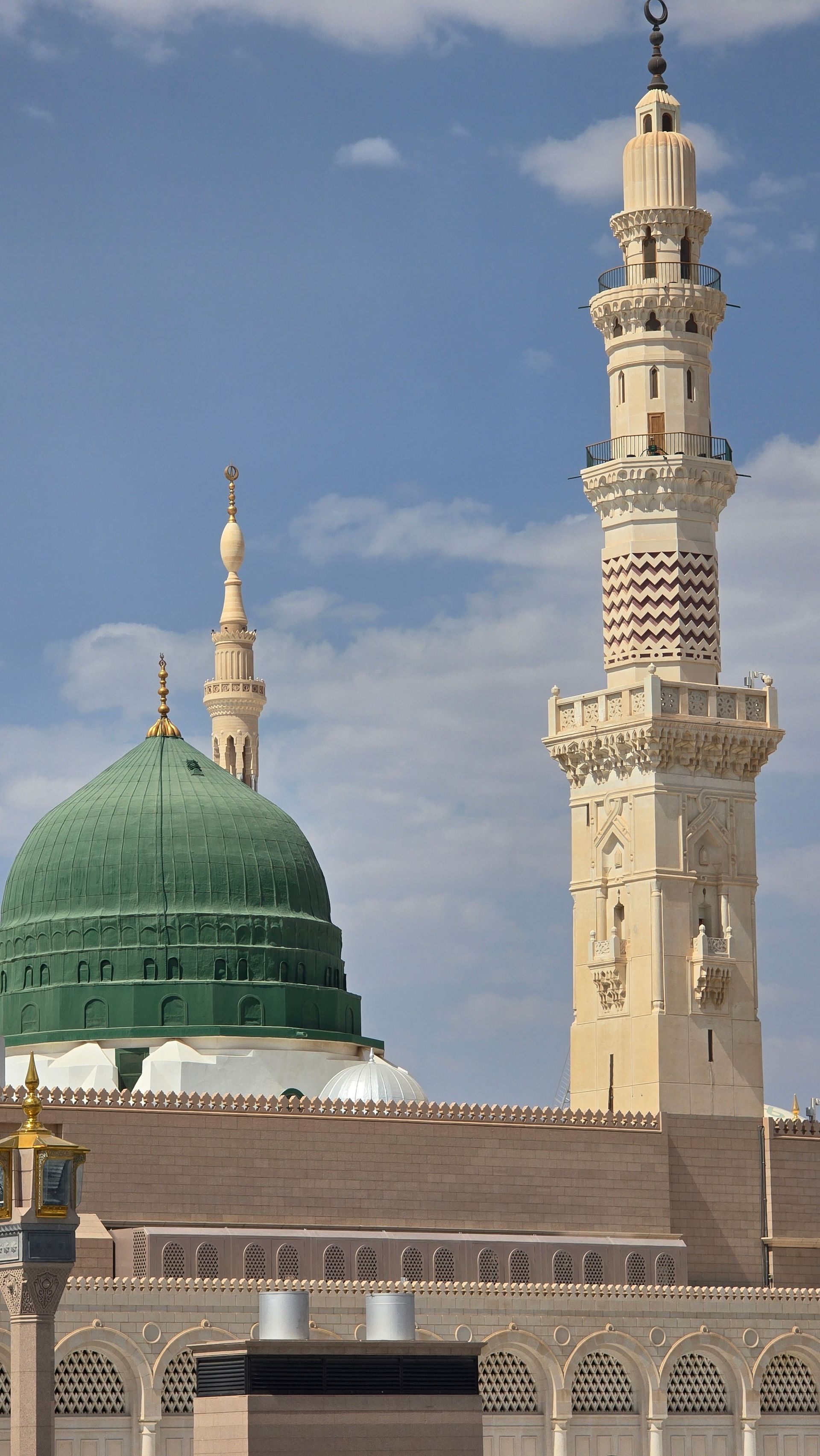 Kubah hijau dan menara Masjid Nabawi di Madinah menjulang menghadap langit biru