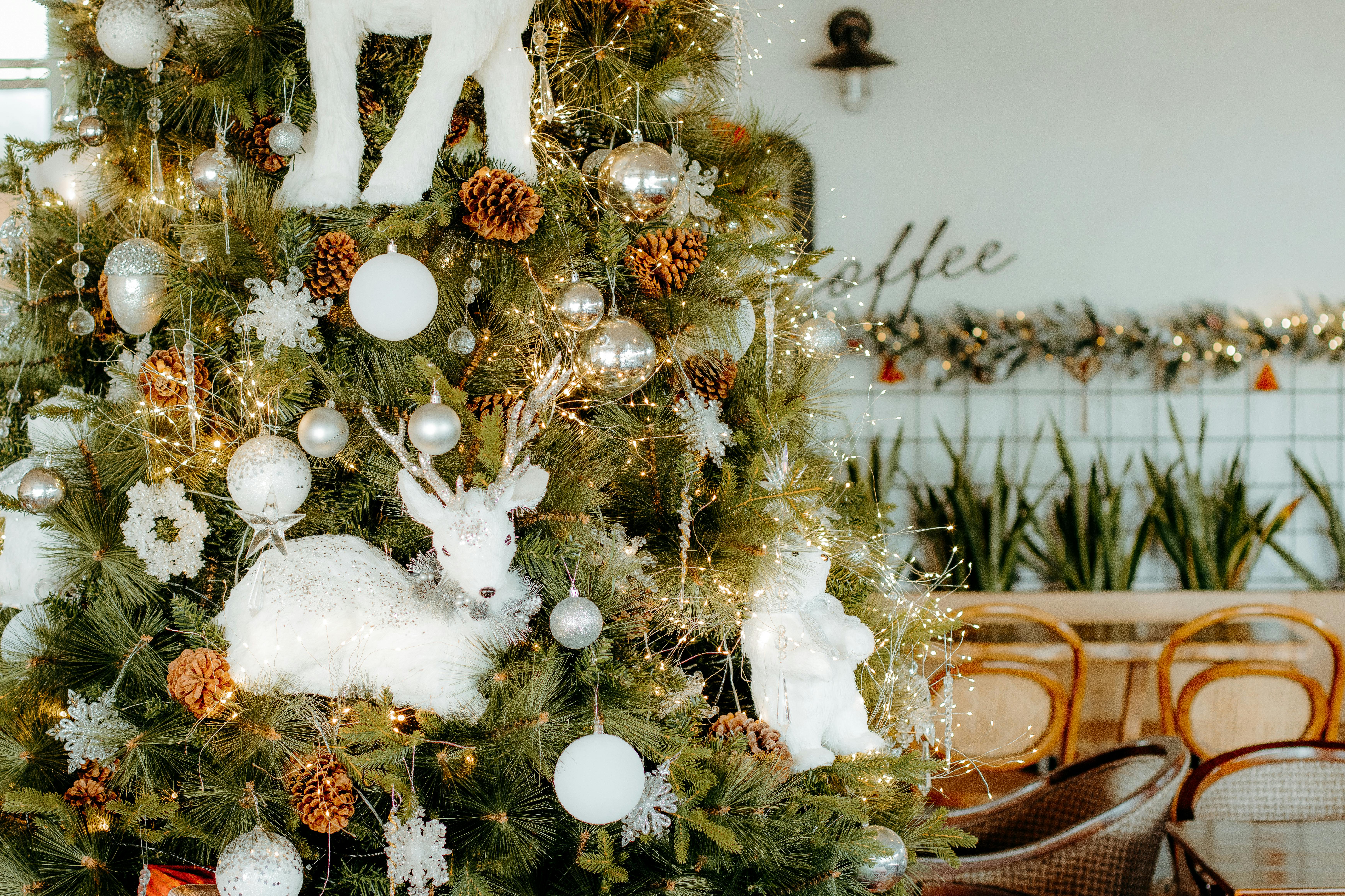 Beautifully decorated Christmas tree with ornaments in a cozy cafe setting, celebrating the holiday season.
