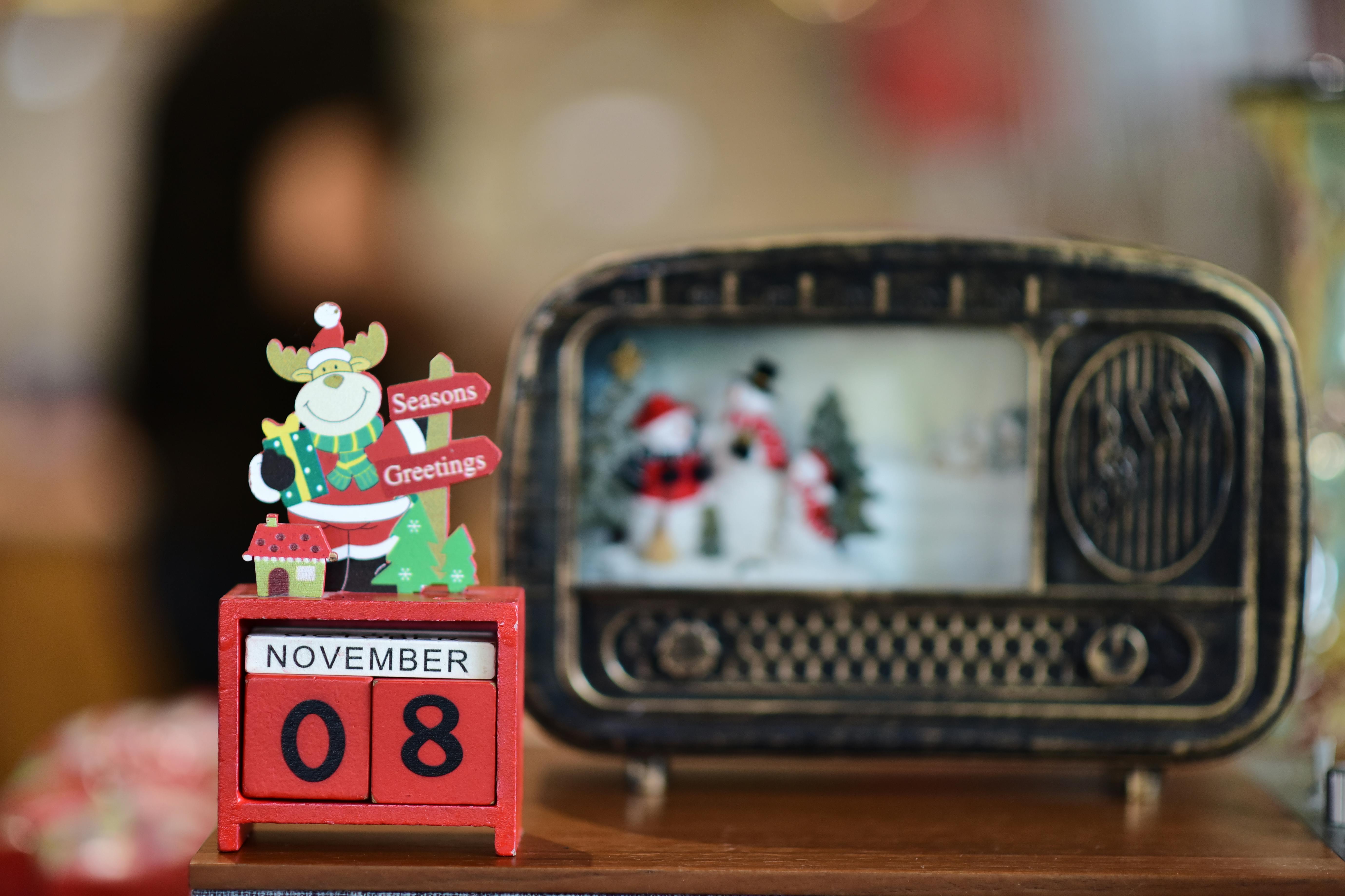 A festive holiday scene featuring a vintage radio and a calendar marking November 8th with decorative elements.