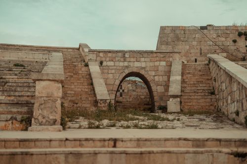 Free A historic stone structure with archways and stairs, showcasing Aleppo's ancient architectural beauty. Stock Photo