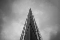 一张黑白戏剧性图像以清晰的视角捕捉了摩天大楼在多云天空下的景象