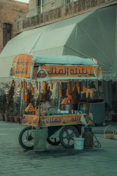 Colorful street food cart selling corn and snacks in a Middle Eastern market.