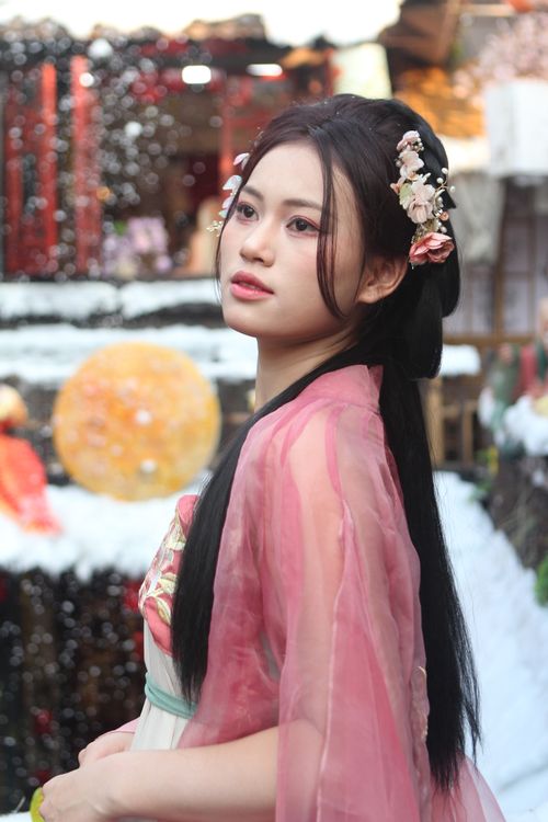 Free A woman in traditional attire with floral decorations, set against a festive, colorful backdrop. Stock Photo