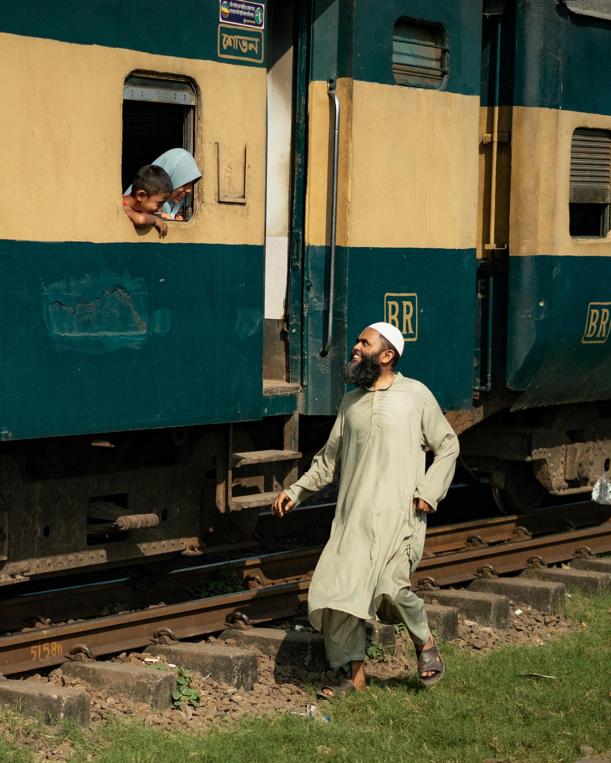 A candid moment at a Dhaka railway station showcasing everyday life and human connection.