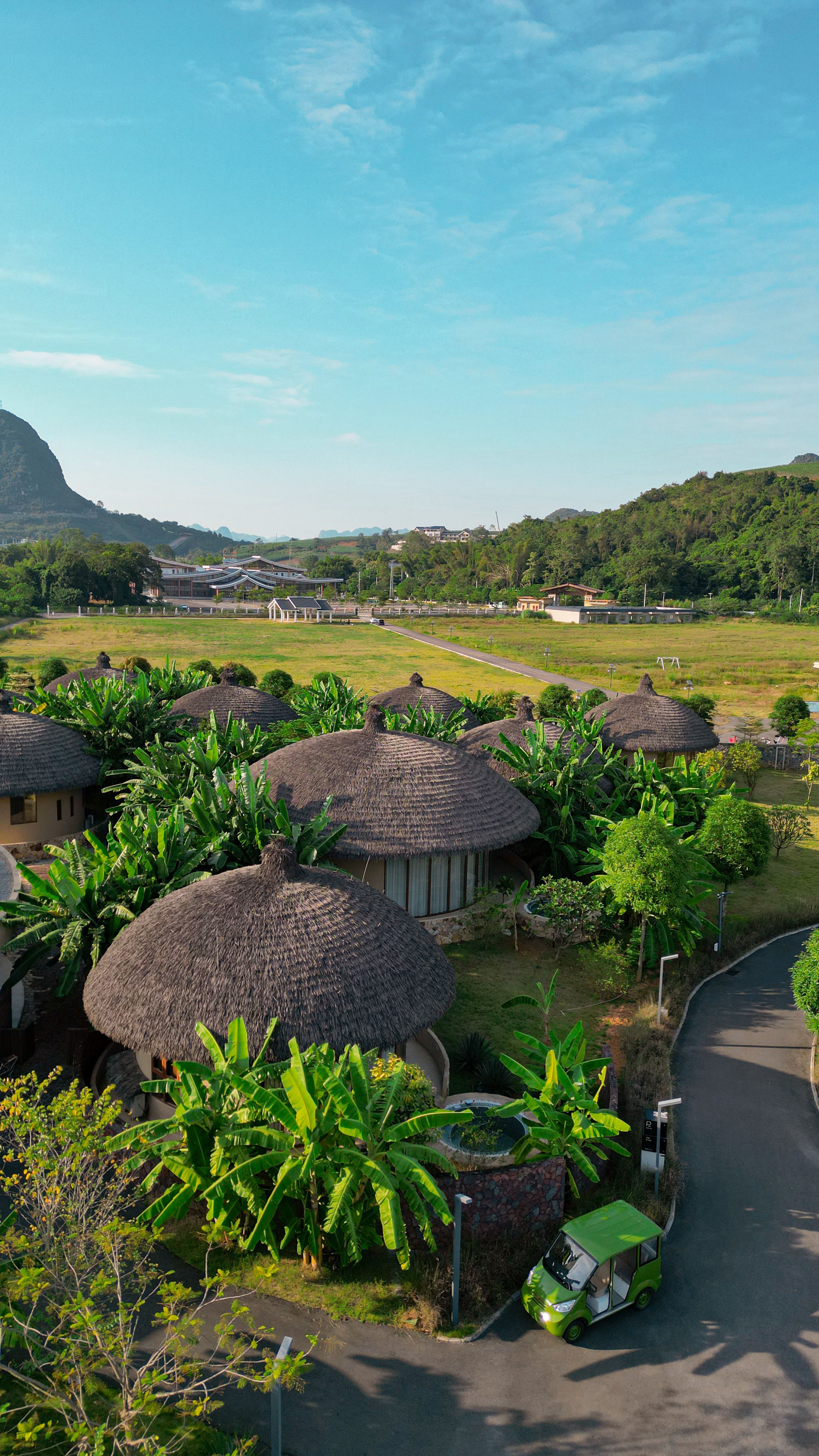 Aerial view of traditional round houses amidst lush greenery in Guangxi, China.