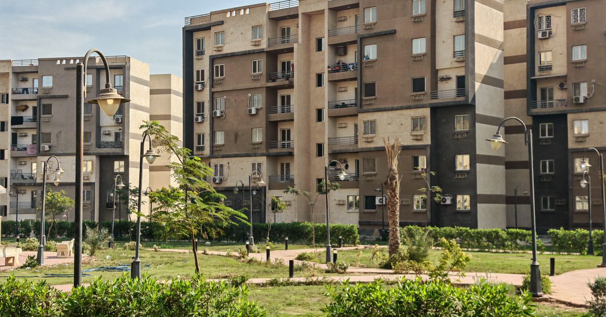 A modern residential building complex with lush greenery and public park.