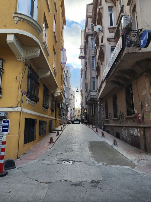 Free A narrow urban alleyway flanked by colorful historic buildings. Stock Photo