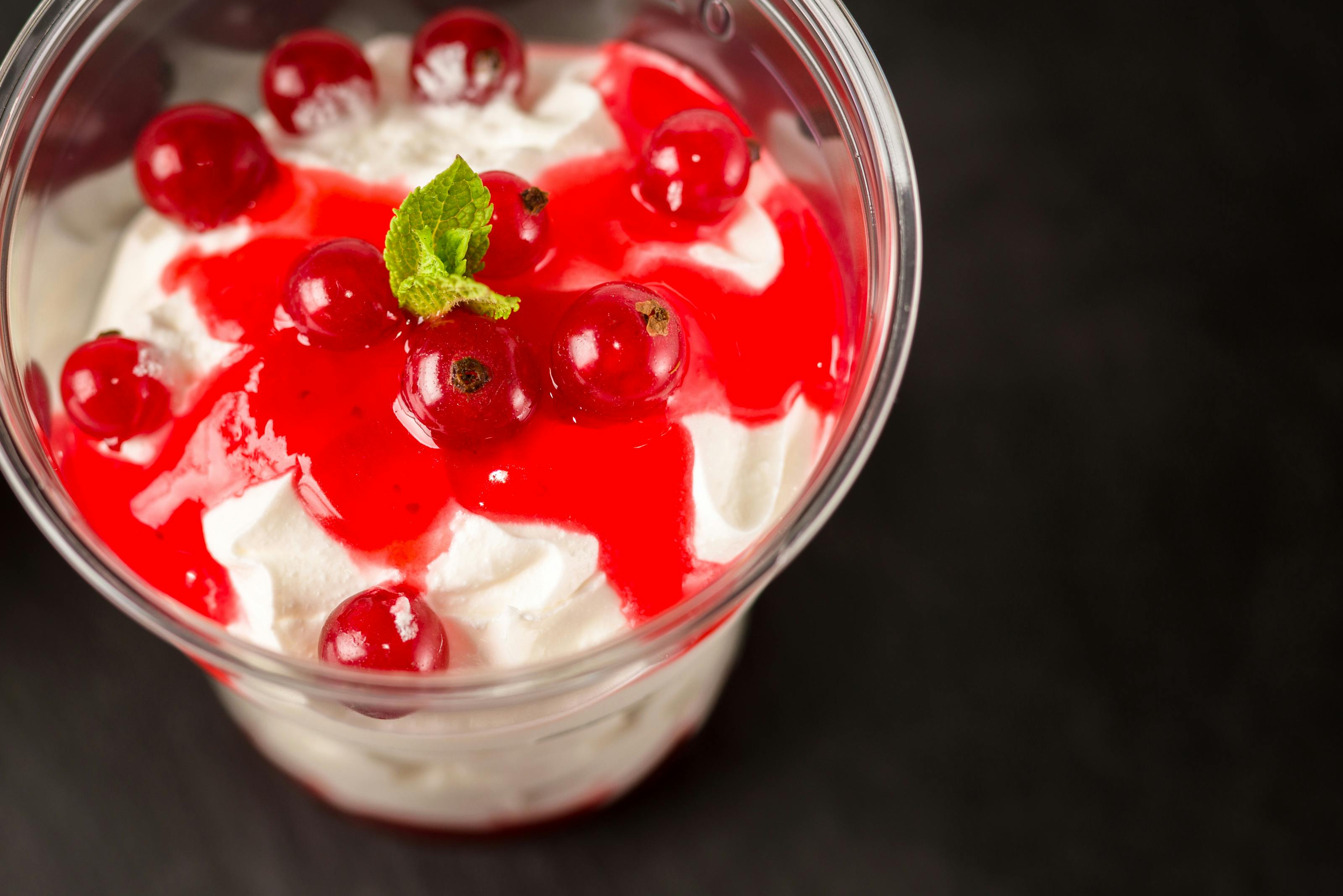 small glass dish of creamy cottage cheese dessert topped with fresh raspberries and mint
