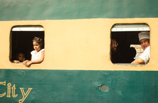 Passengers, including children, look out from a train window in Dhaka City, Bangladesh.