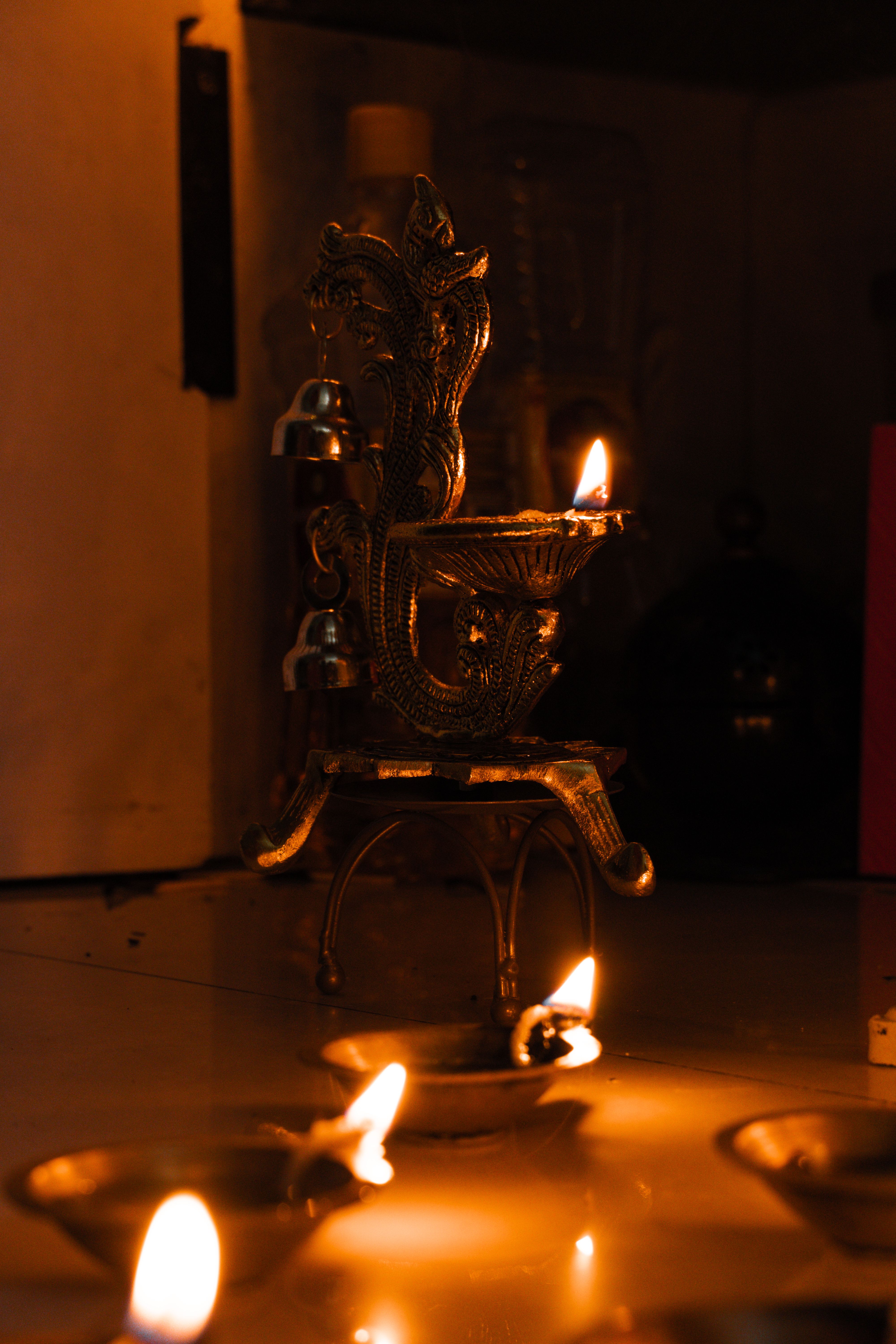 Indoor scene of Diwali celebration featuring traditional lit oil lamps in warm, festive ambiance.