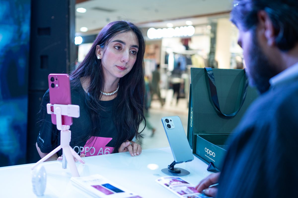 Second-hand or transferred SIM — customer at a mobile retail counter in Islamabad