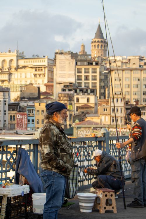 Free Fishermen on Galata Bridge in Istanbul with scenic view of city skyline and Galata Tower. Stock Photo