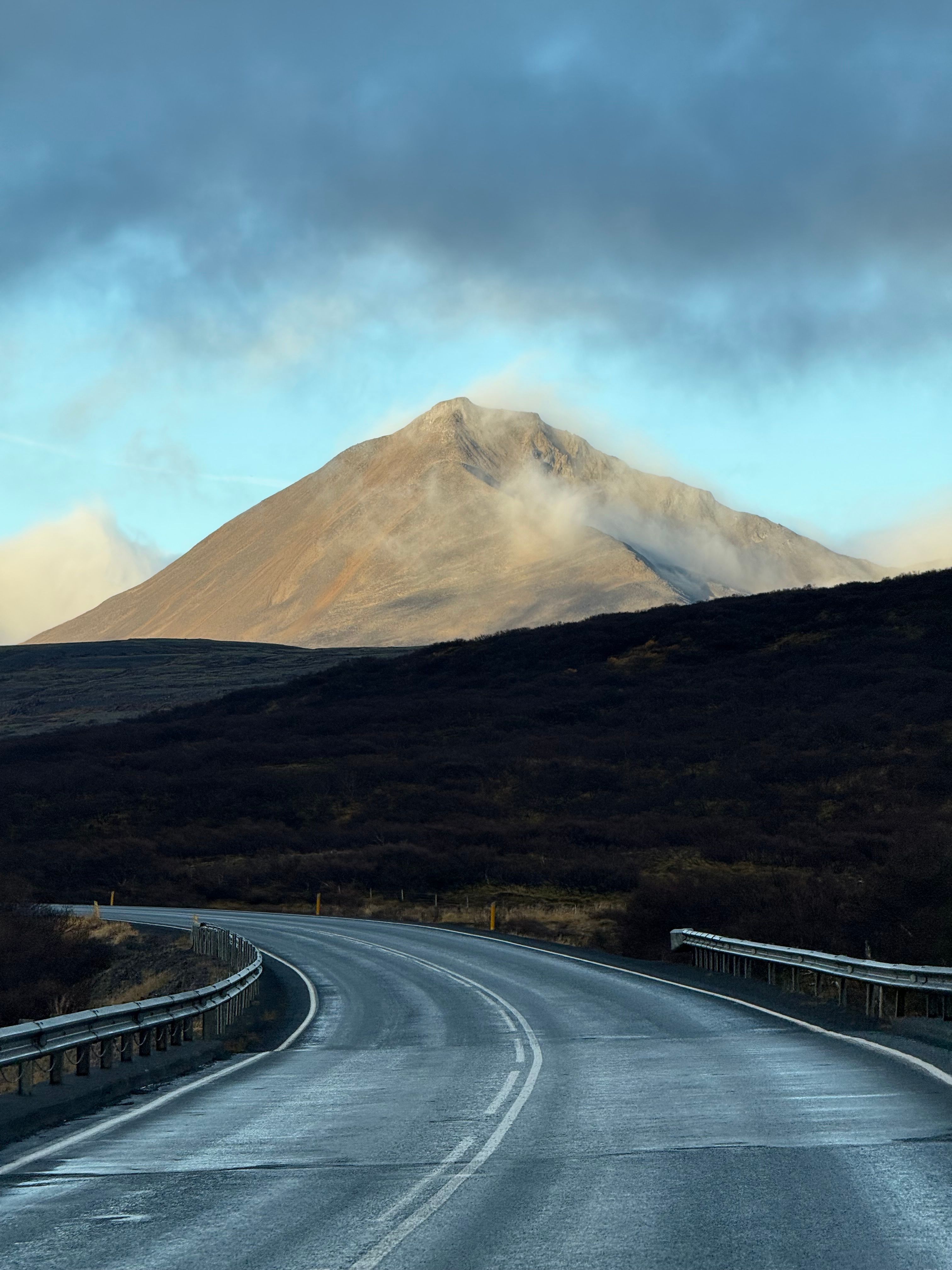 Serene morning view of a winding road leading to a misty mountain in Iceland, perfect for nature enthusiasts.