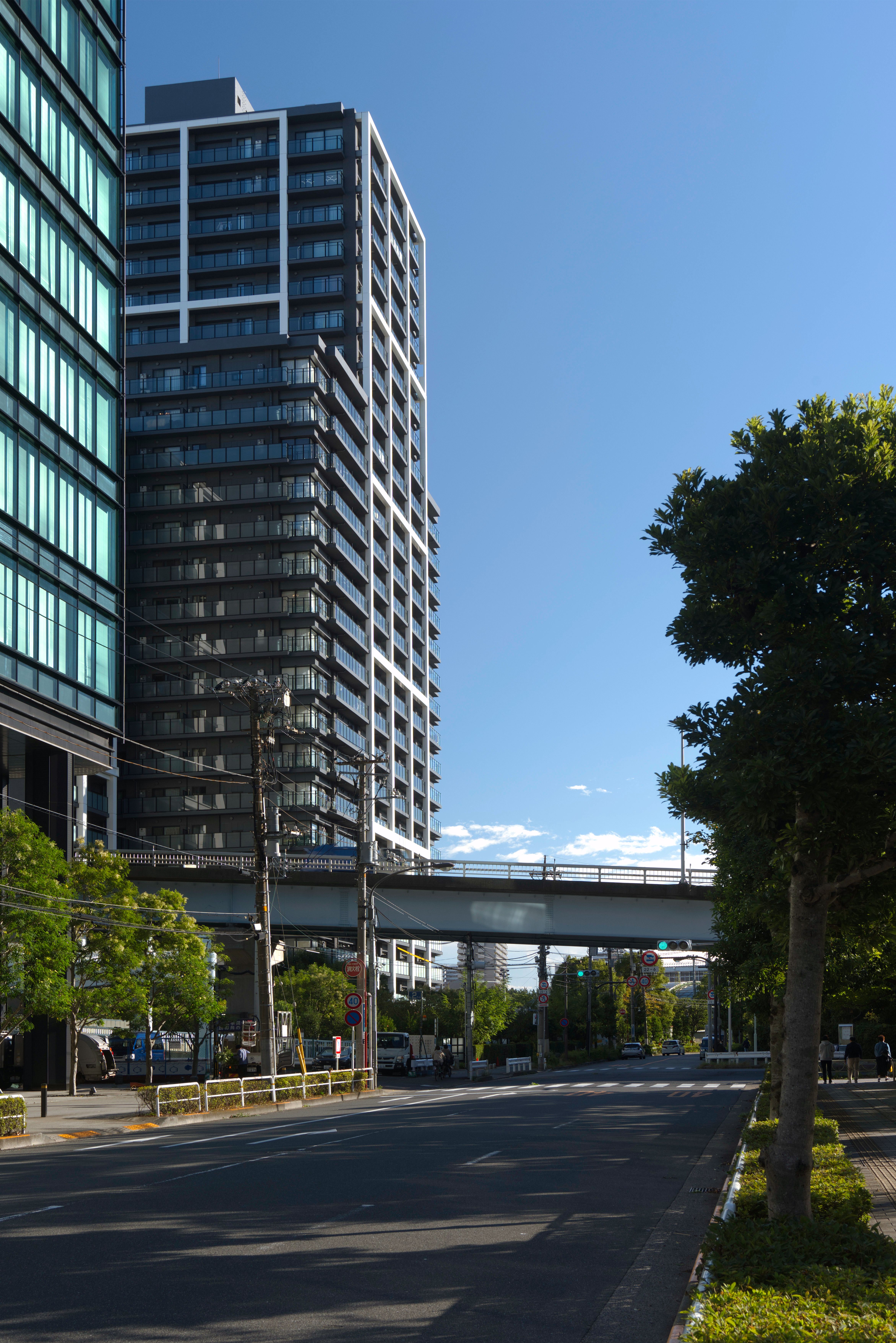 View of a modern highrise building and street in Shinagawa City, Tokyo, under a clear blue sky.