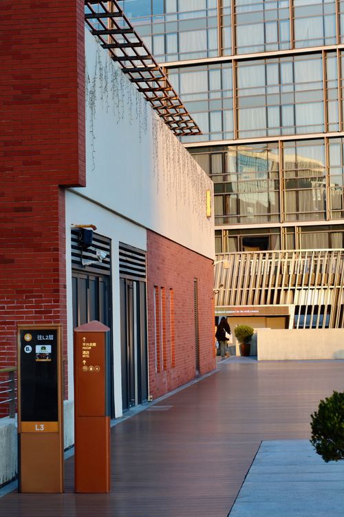 Free Modern urban street scene with reflective glass buildings and red brick facade. Stock Photo