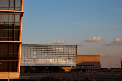 Free Sunset view of modern office building with reflective glass facade against a clear sky. Stock Photo