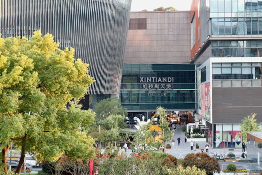 A bustling view of a modern plaza at Xintiandi The Hub, showcasing urban life.