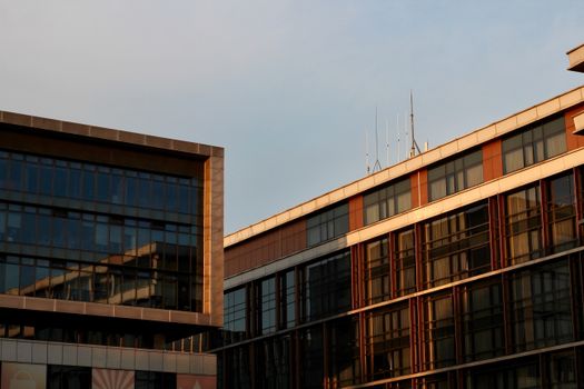Sunlight illuminates a modern building exterior with reflective windows.