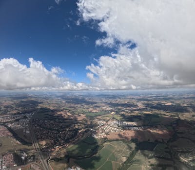 Stunning aerial view of a rural landscape with sprawling fields under a vivid blue sky.