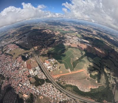 Gorgeous aerial view showcasing urban and rural landscapes with fields and clouds.