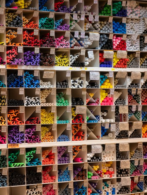 Free Vibrant array of art supplies neatly organized in shelves, offering a rainbow of colors and textures. Stock Photo