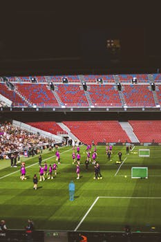 Professional soccer team practicing on a stadium field during daylight.