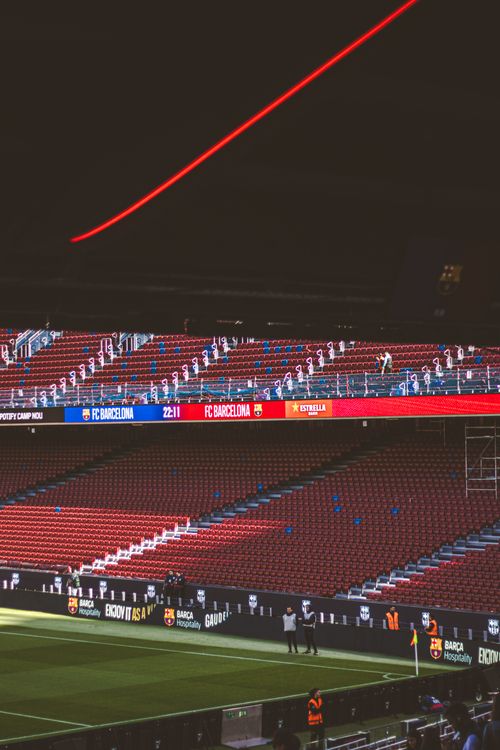 Free Empty soccer stadium with striking red accents during twilight, showcasing a calm sports atmosphere. Stock Photo