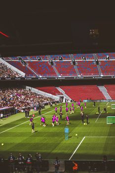 Professional soccer team practicing on field with stadium audience view.