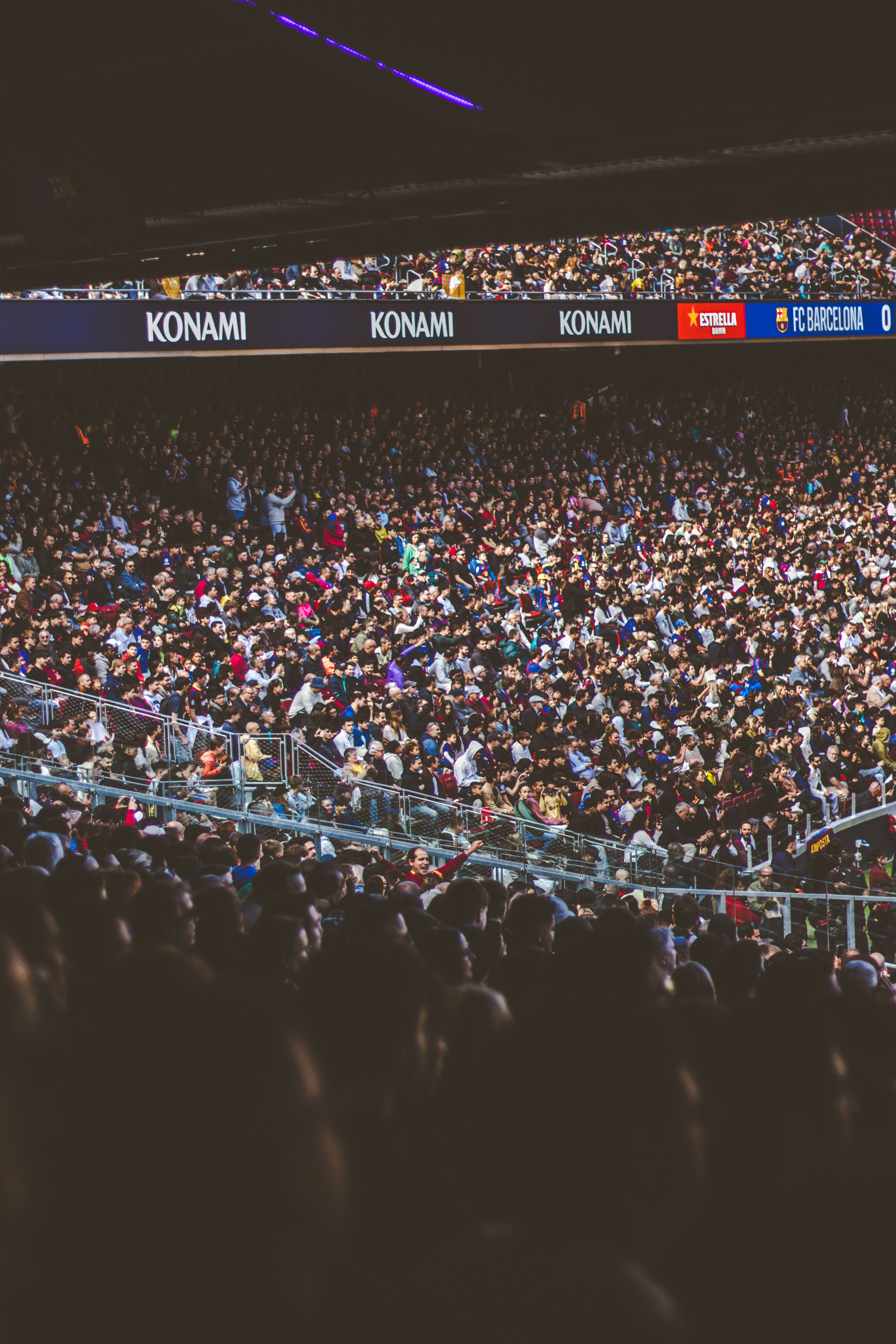 A vibrant football crowd filling a stadium during a daytime match