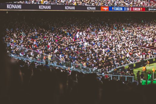 A vibrant crowd fills a football stadium during a lively match.