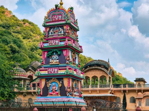 Free Colorful Hindu temple architecture in Jaipur, surrounded by lush greenery and blue skies. Stock Photo